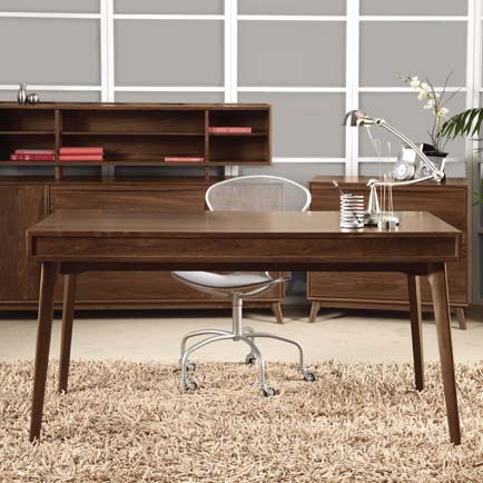 A modern home office with a desk, chair and bookshelf.