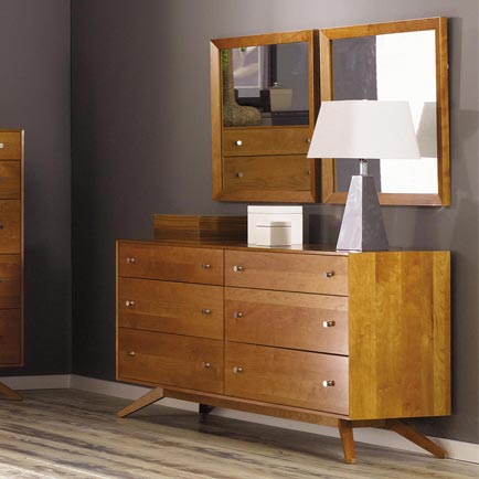 A wooden dresser and mirror in a room.