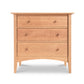 A sustainably harvested Maple Corner Woodworks American Shaker 3-Drawer Chest with round knobs and curved legs, isolated on a white background.