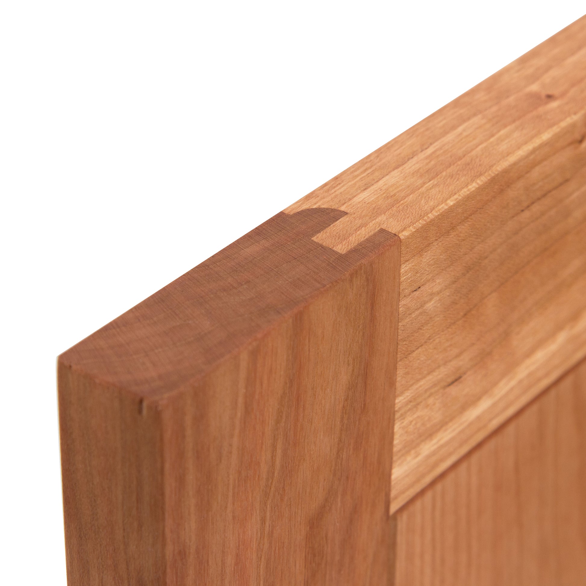 Detailed view of a wooden dovetail joint in an American Shaker 1-Drawer Nightstand with Door by Maple Corner Woodworks, highlighting exquisite craftsmanship with sustainably harvested wood.