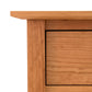Close-up view of a Maple Corner Woodworks American Shaker 5-Drawer Chest corner with a drawer, showing fine wood grain and a simple, clean design. The drawer is closed and fits flush against the table frame.