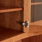 A close-up view of a wooden cabinet hinge on a Maple Corner Woodworks American Shaker 50" China Cabinet, showing the detail of the carpentry and hardware.
