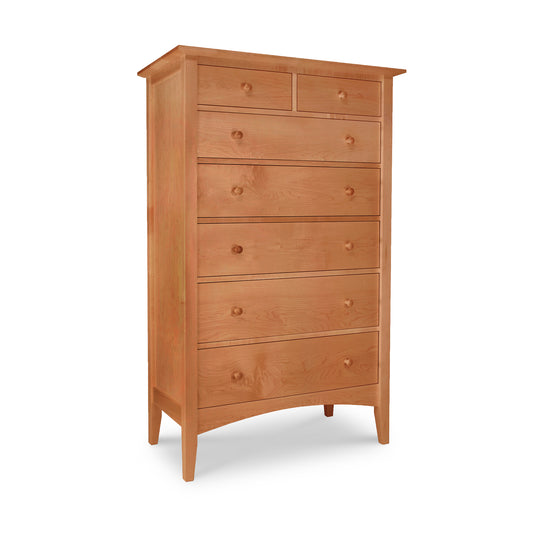A tall dresser from the Maple Corner Woodworks American Shaker Furniture Collection with seven drawers in various sizes, featuring simple handles and standing on four legs, isolated against a white background.