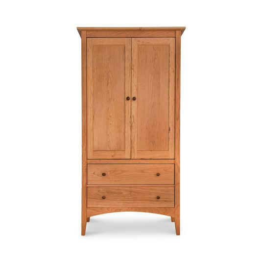 American Shaker Armoire from Maple Corner Woodworks, crafted from solid wood with a natural finish, two doors and two drawers with round knobs, showcasing timeless style and functionality.