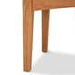 Close-up of a Maple Corner Woodworks American Shaker Coffee Table leg with a smooth finish and visible wood grain, standing on a plain white background.
