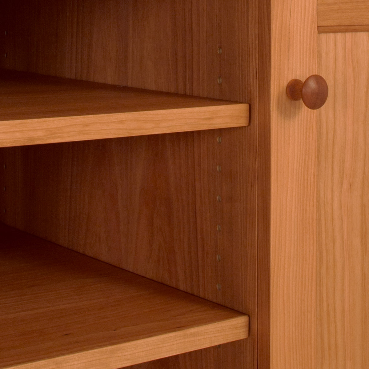 Close-up of an open American Shaker 67" TV Stand crafted from solid hardwoods by Maple Corner Woodworks, with empty shelves that spotlight the natural wood texture and visible pegs for adjusting shelf height.