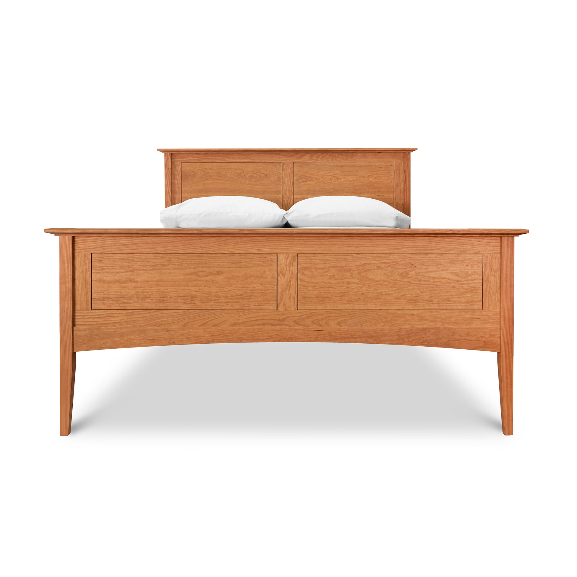A Maple Corner Woodworks American Shaker Panel Bed with a high headboard featuring two Shaker panel designs, finished in a light oak color. The bed is made up with white pillows.