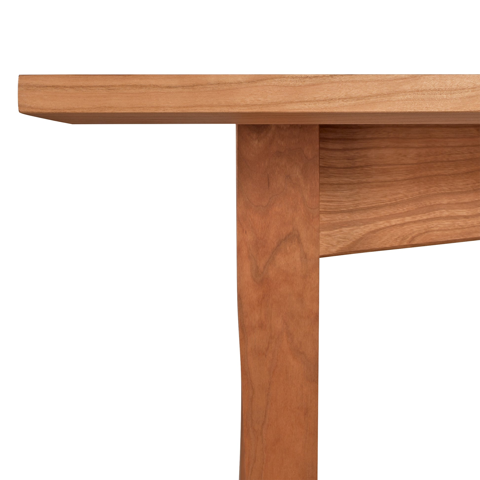 Close-up of a Maple Corner Woodworks American Shaker Rectangular Solid Top Table showing a section of the tabletop and a supporting leg, highlighting the natural wood grain and smooth finish.
