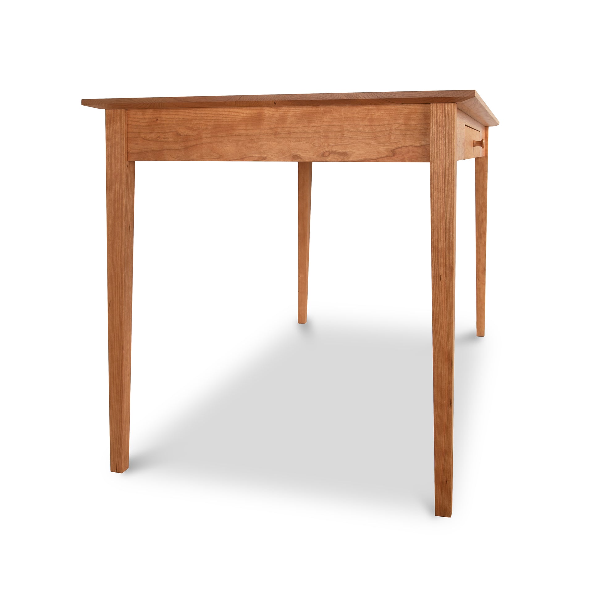 An Maple Corner Woodworks American Shaker writing desk crafted from sustainably harvested hardwood with a simple design and a drawer, isolated on a white background.
