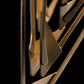 A close up of a Hubbardton Forge Amulet Mini Pendant metal sculpture with a black background.