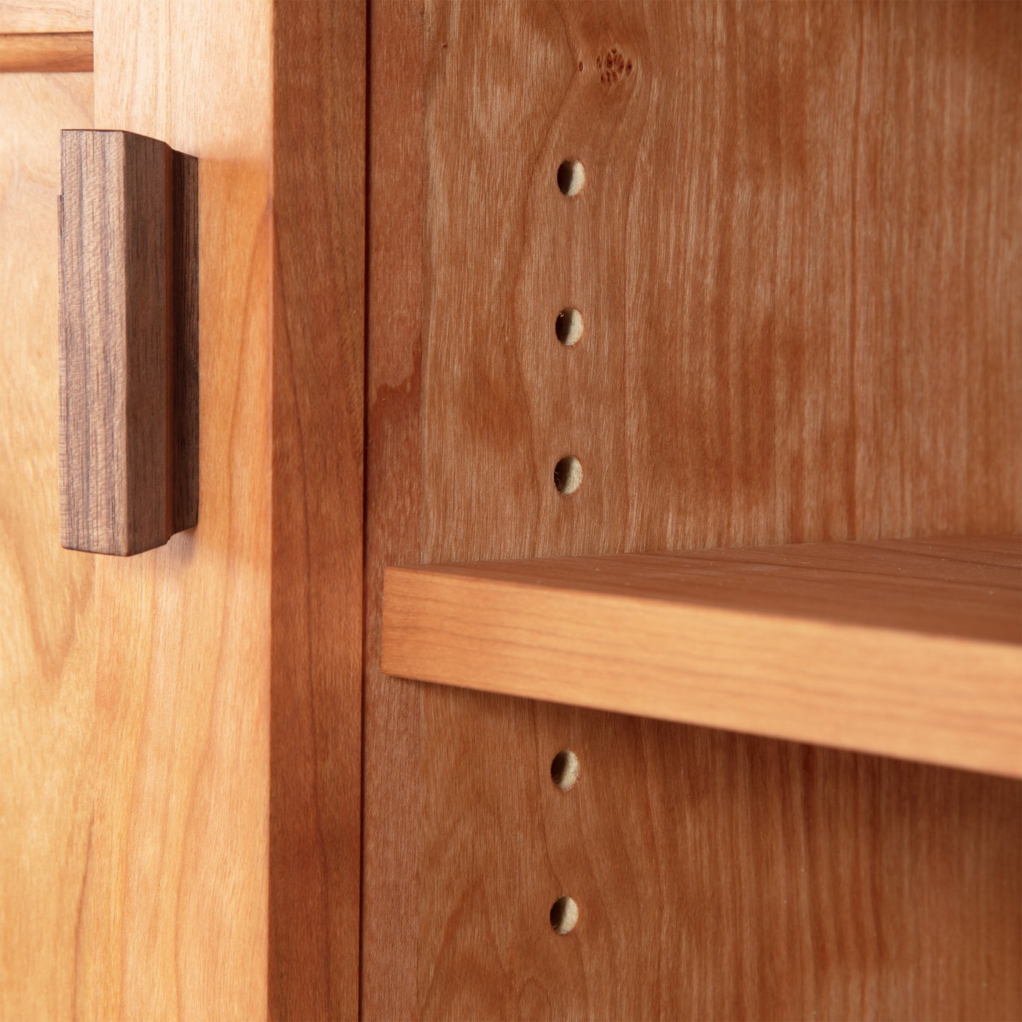 Andover Modern 64" TV Stand showcasing adjustable shelf holes and door handle, crafted with sustainable hardwood by Maple Corner Woodworks, exemplifying Vermont craftsmanship.