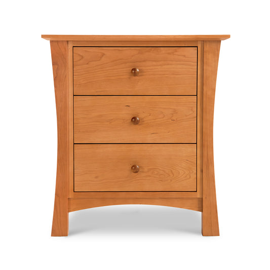 Lyndon Furniture Andrews 3-Drawer Nightstand in natural cherry with round knobs and flared legs, highlighting its craftsmanship and elegant wood finish.