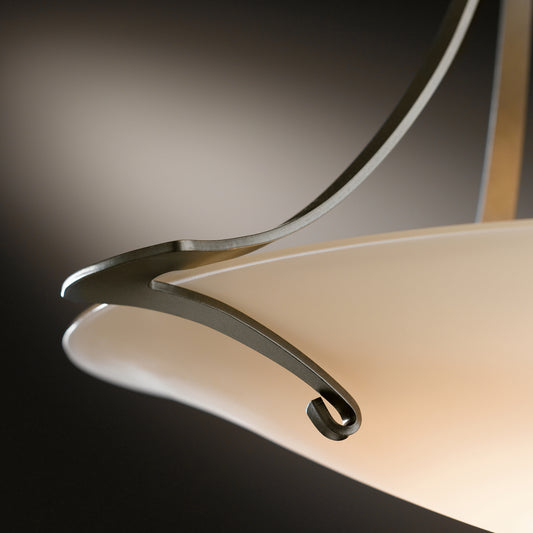 Hubbardton Forge Antasia Pendant, modern ceiling light with curved metal design and cream glass shade, showcasing fine craftsmanship.