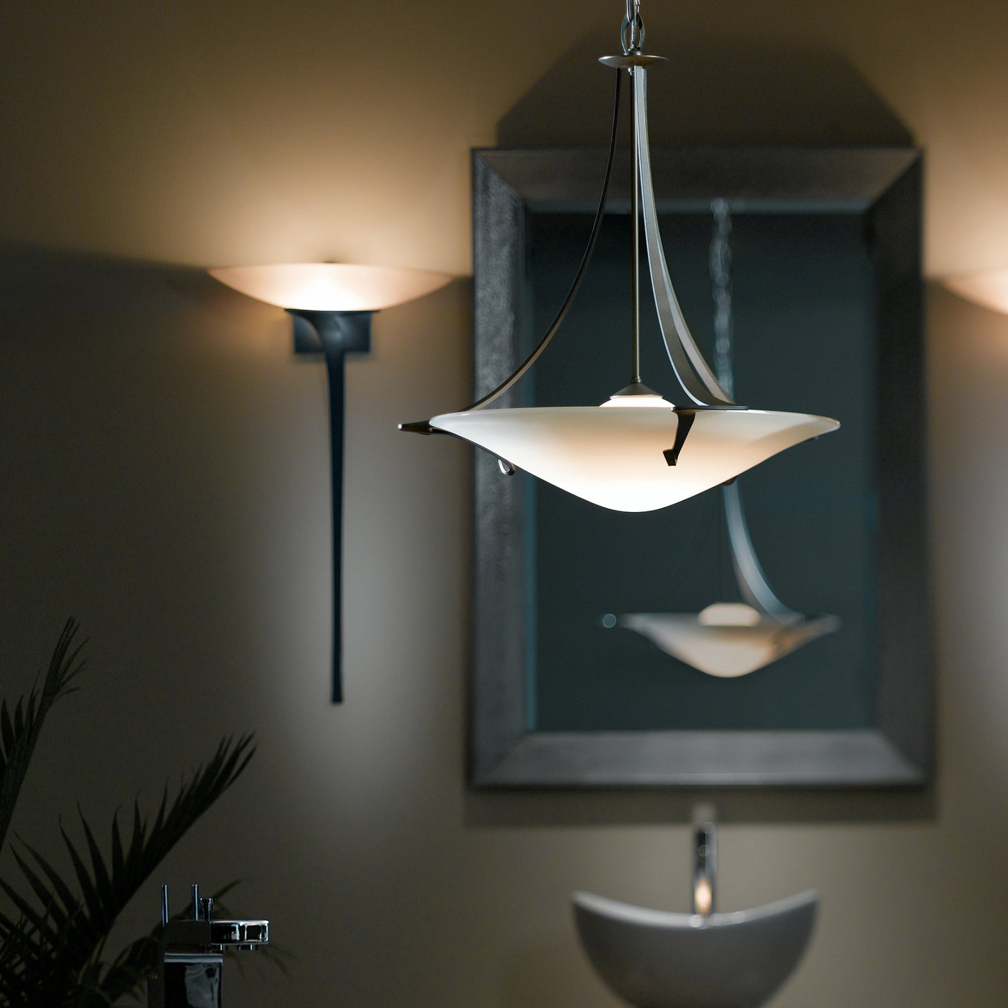 Elegant Antasia Pendant with curved design brightly illuminates, complemented by intricate detailing of Hubbardton Forge sconces.
