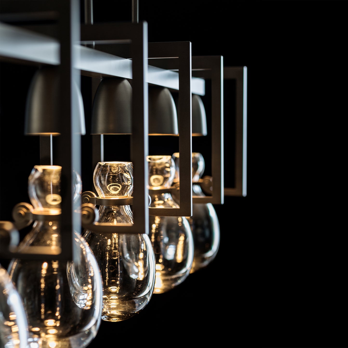 Apothecary Pendant lights by Hubbardton Forge with hand-blown glass bulbs and metal frames.