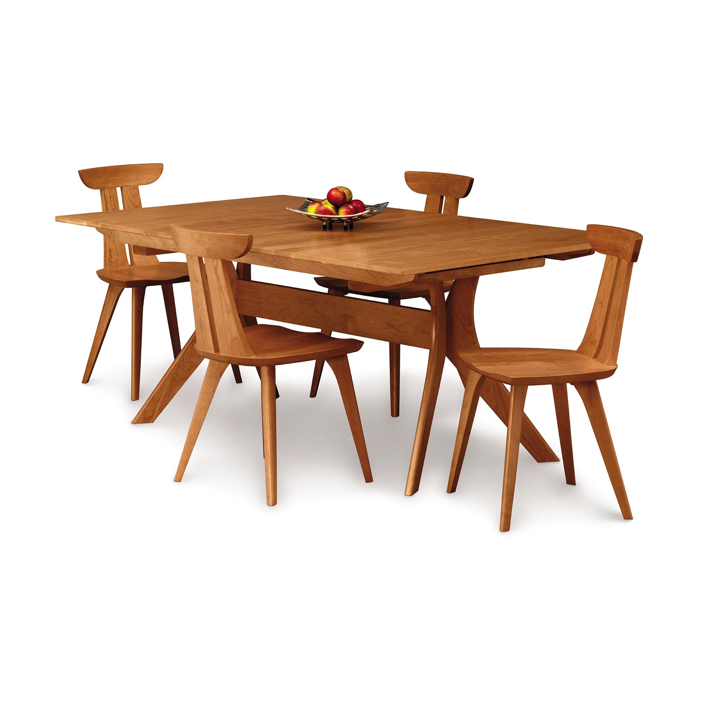 A handmade solid Cherry wood Audrey Extension Dining Table with four Copeland Furniture chairs set on a white background, a fruit bowl in the center of the table.
