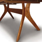 Close-up of a solid cherry wood Audrey Extension Dining Table by Copeland Furniture showing detail of the grain and structure of the legs and underside.