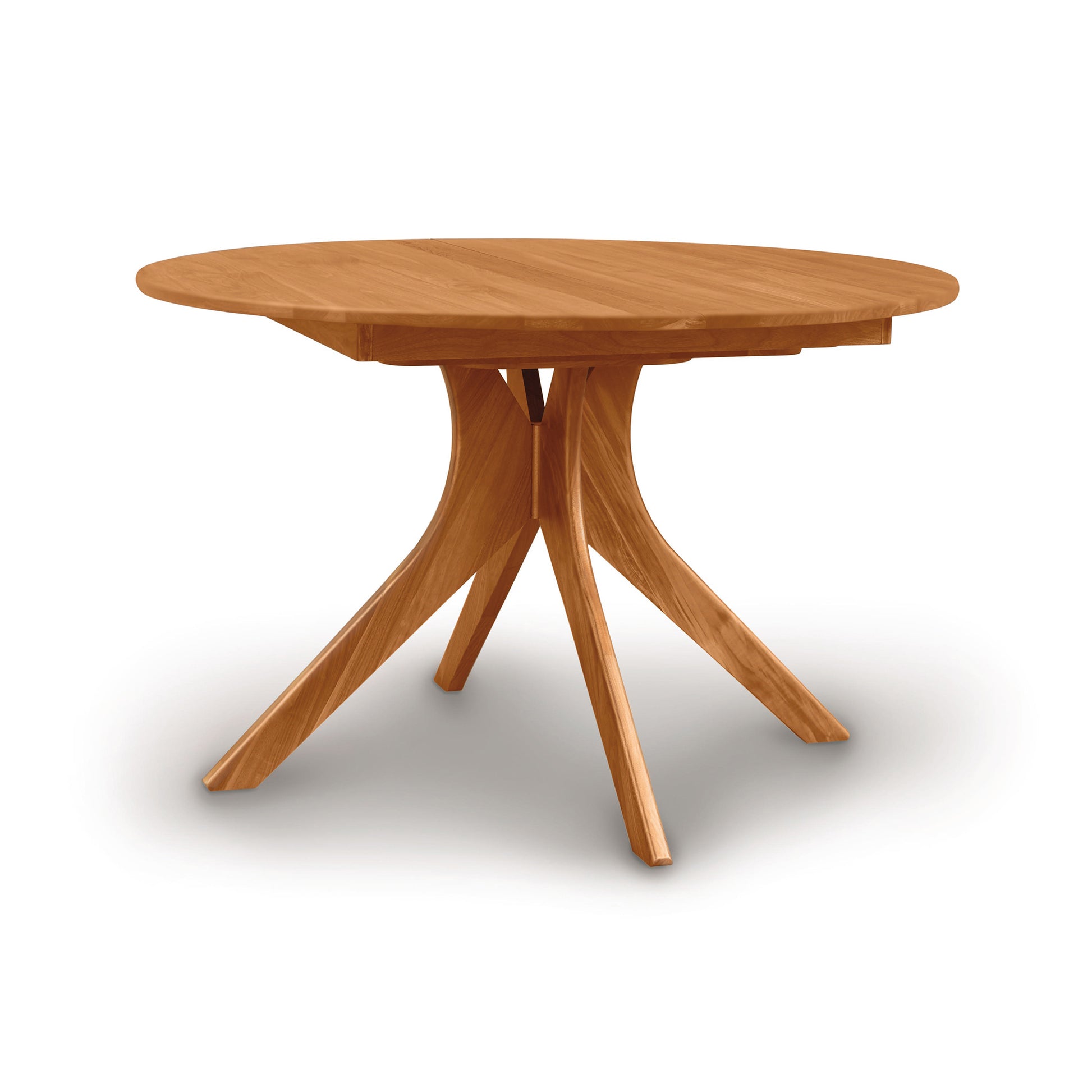 Audrey Round Extension Dining Table by Copeland Furniture with a solid wood top and four angled legs, showcasing fine craftsmanship.