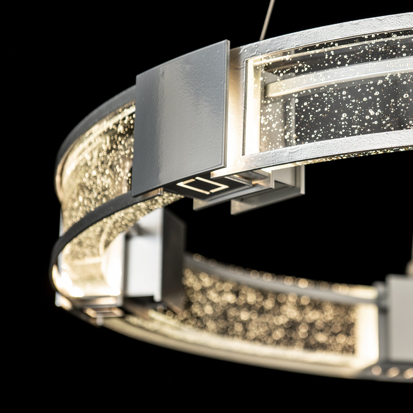 Close-up of the Aura Glass Pendant by Hubbardton Forge, featuring a sleek modern design with bubble-like LEDs, perfect as a contemporary chandelier centerpiece.