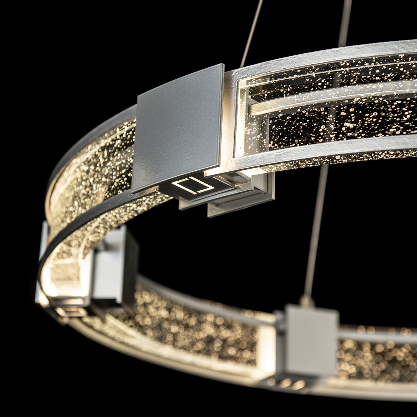 Hubbardton Forge Aura Glass Pendant with metallic frame and LED lights.