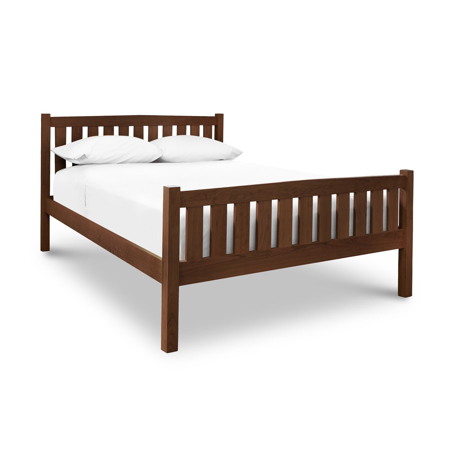 A Bennington Bed with High Footboard from Vermont Furniture Designs, featuring a simple design in walnut wood, two white pillows, and a white bed sheet, isolated on a white background.