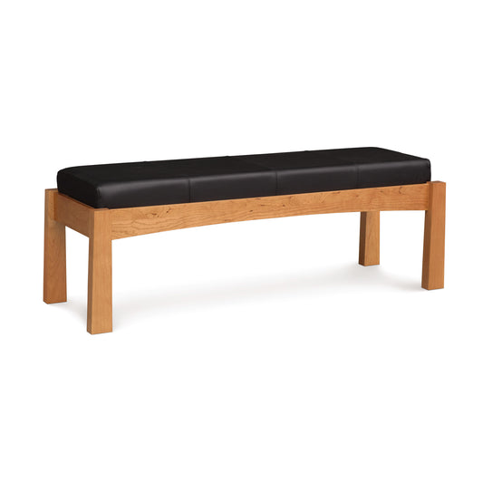 A cherry wood Copeland Furniture Berkeley Upholstered Bench with a black leather cushion on a white background.