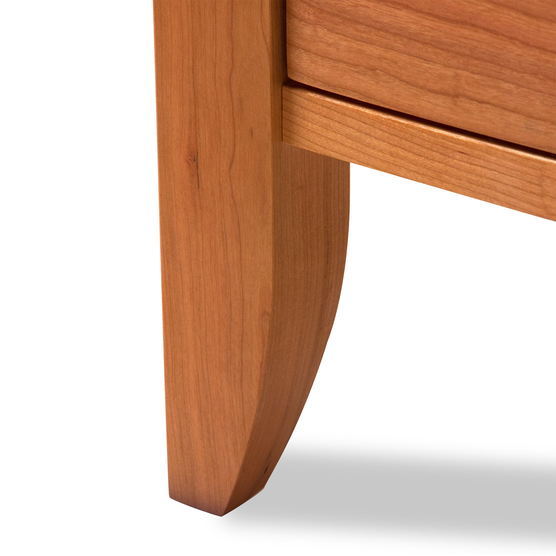 Bow Front 3-Drawer Nightstand by Lyndon Furniture, crafted in Vermont from light brown sustainable wood, highlighting the detailed craftsmanship of the leg.