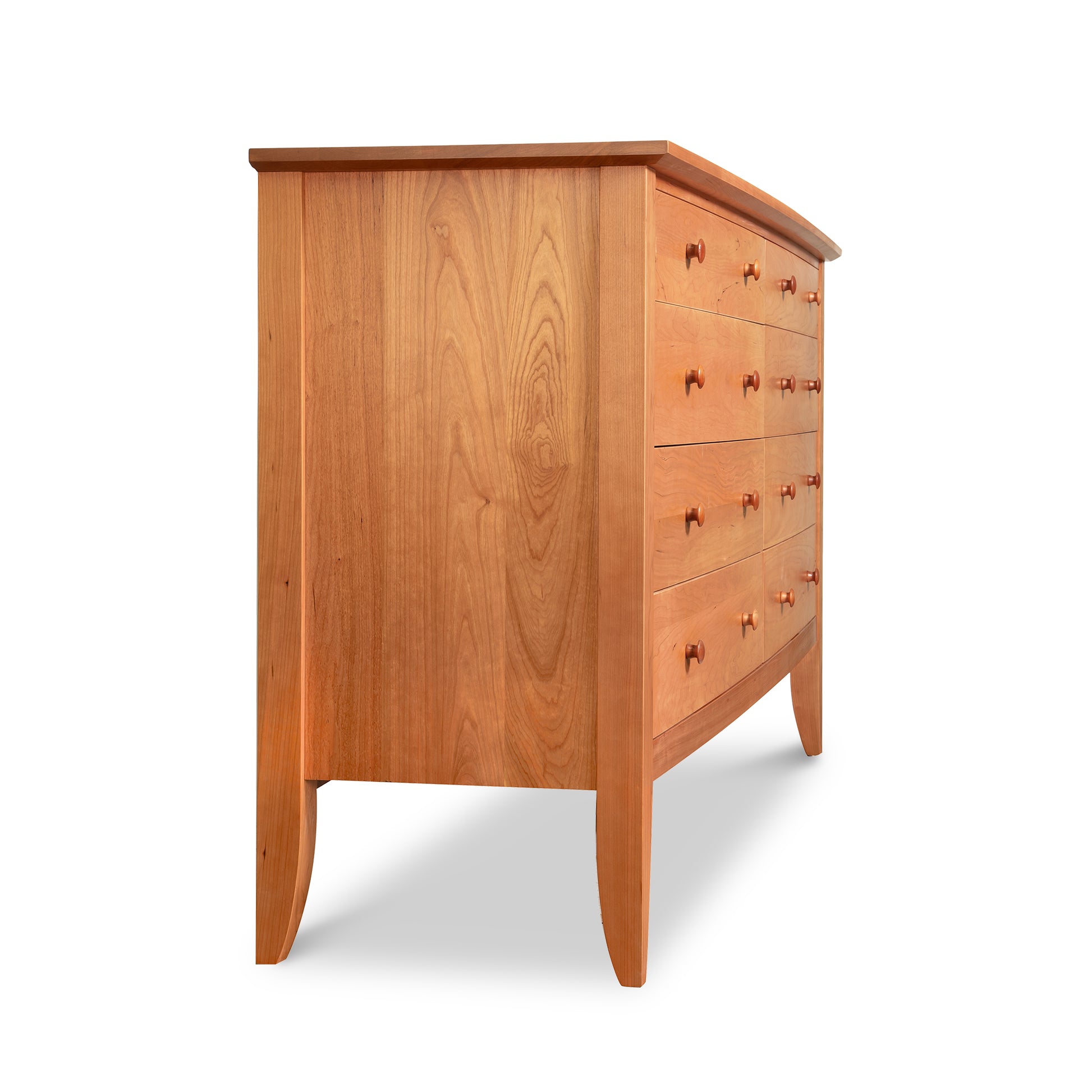 Lyndon Furniture Bow Front 8-Drawer Dresser in sustainable wood with round handles, displayed from an angled side view to highlight its craftsmanship and design.
