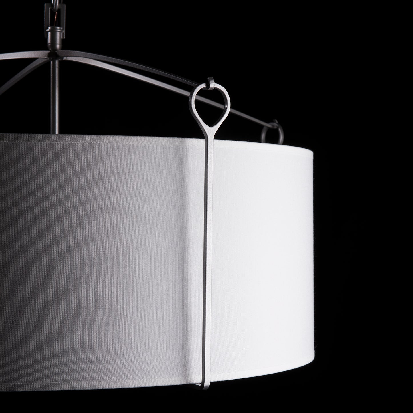 Bow Pendant by Hubbardton Forge showcasing its elegant white cylindrical lampshade and sleek metal frame.