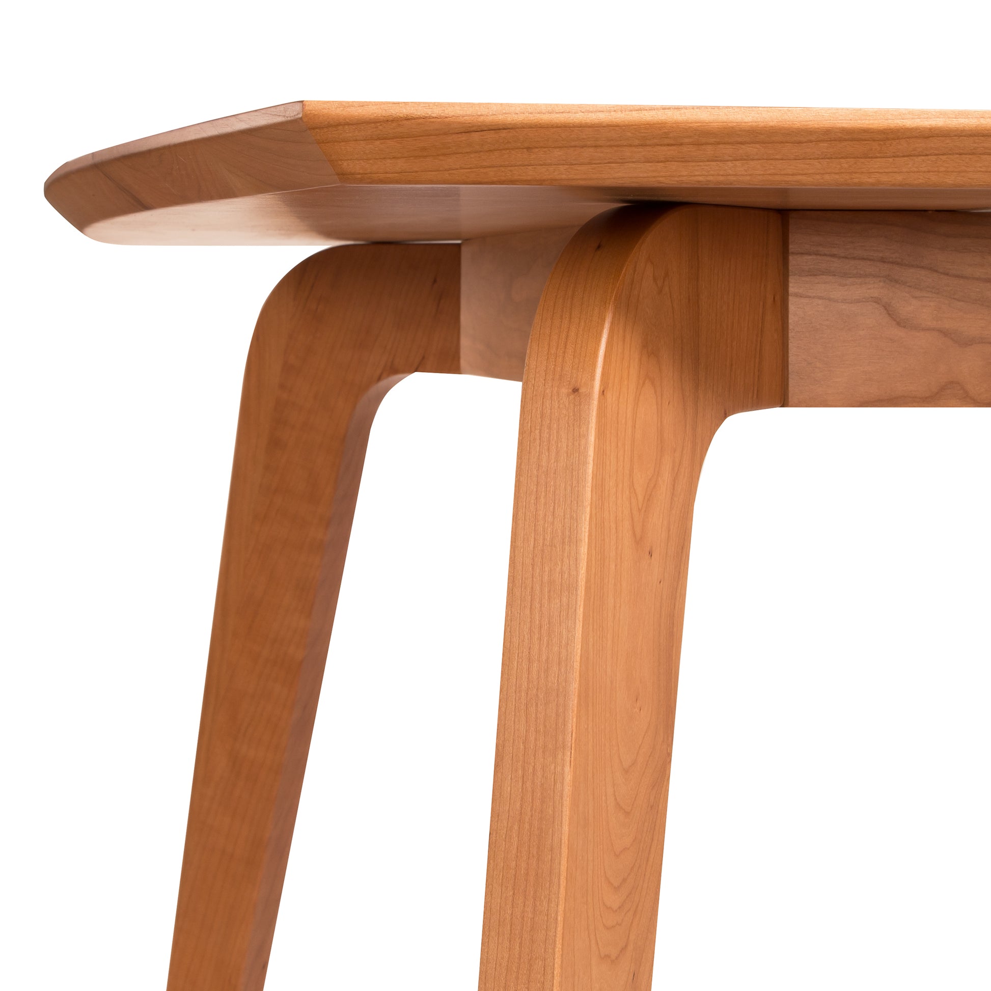 A close-up view of the Lyndon Furniture Brighton Solid-Top Dining Table featuring solid wood construction, a smooth tabletop, and elegantly curved legs, with a focus on its natural wood grain and craftsmanship.