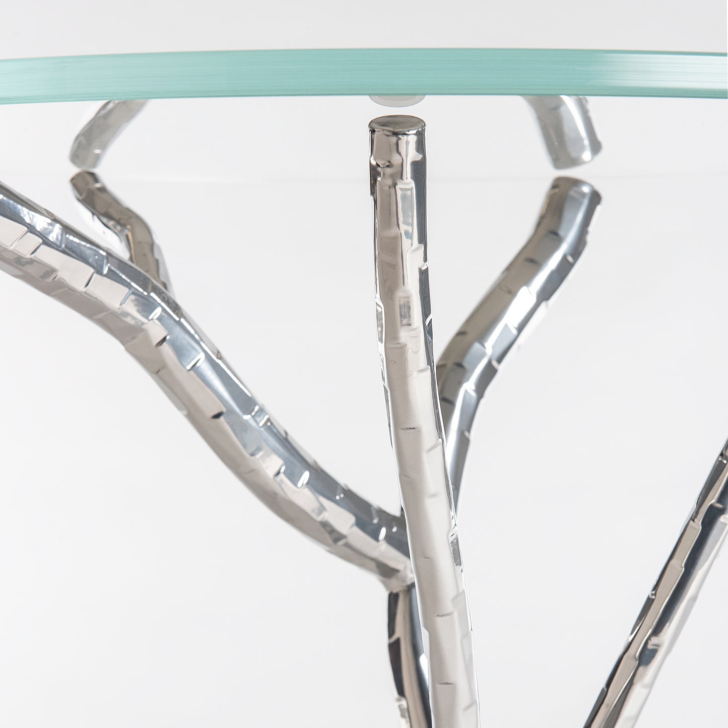 Brindille Accent Table by Hubbardton Forge, showcasing a handcrafted silver branch base and tempered glass top, highlighting its elegant design.