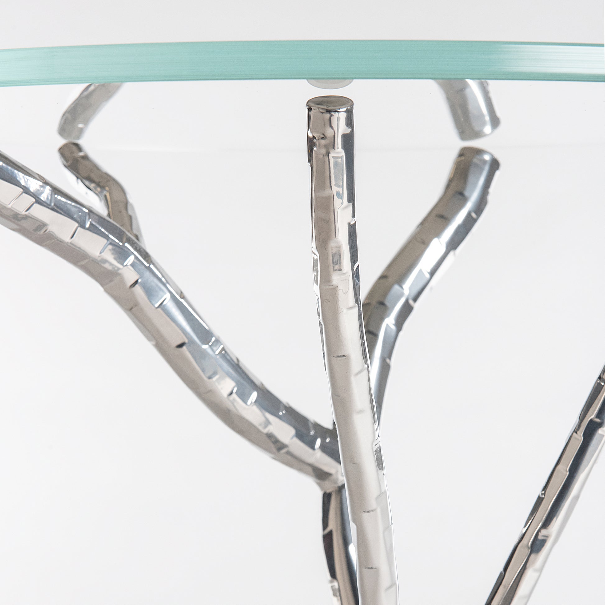 Brindille Accent Table by Hubbardton Forge, showcasing a handcrafted silver branch base and tempered glass top, highlighting its elegant design.