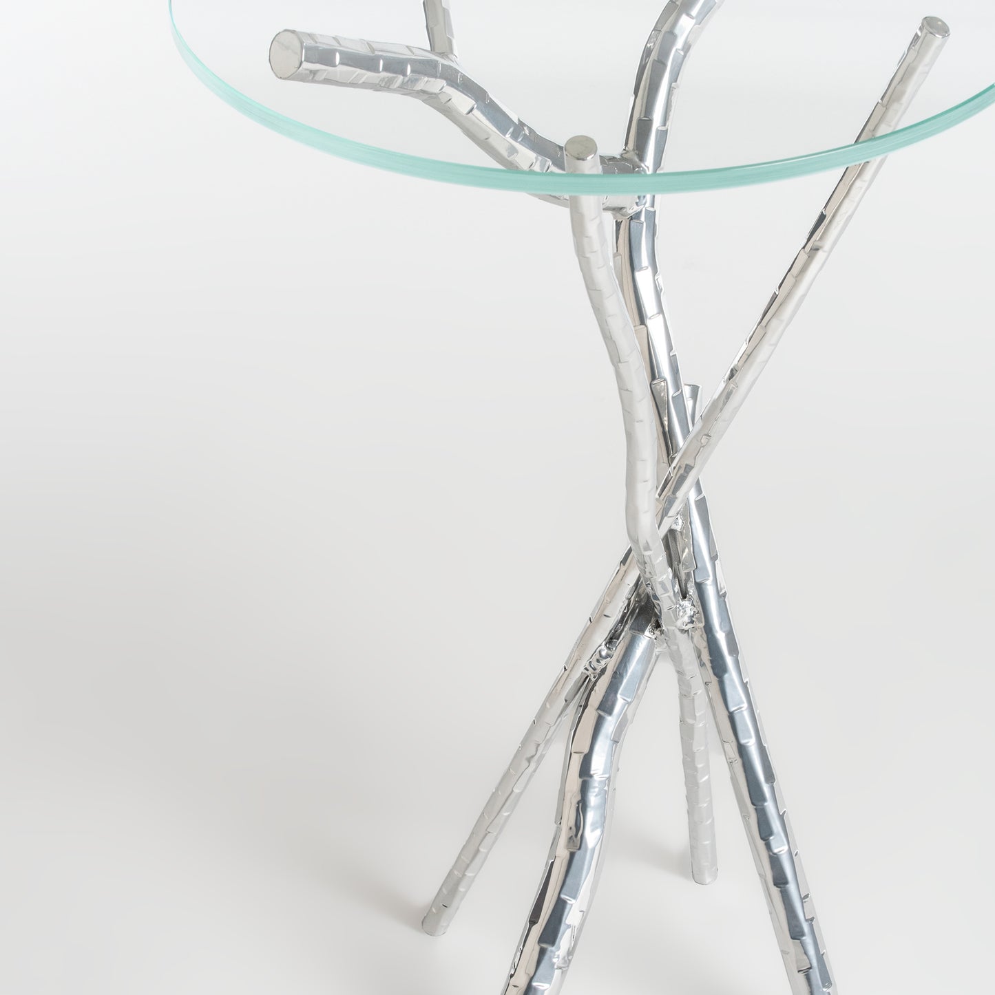 Brindille Accent Table by Hubbardton Forge with tempered glass top and artistic tripod base of intertwined metallic branches.