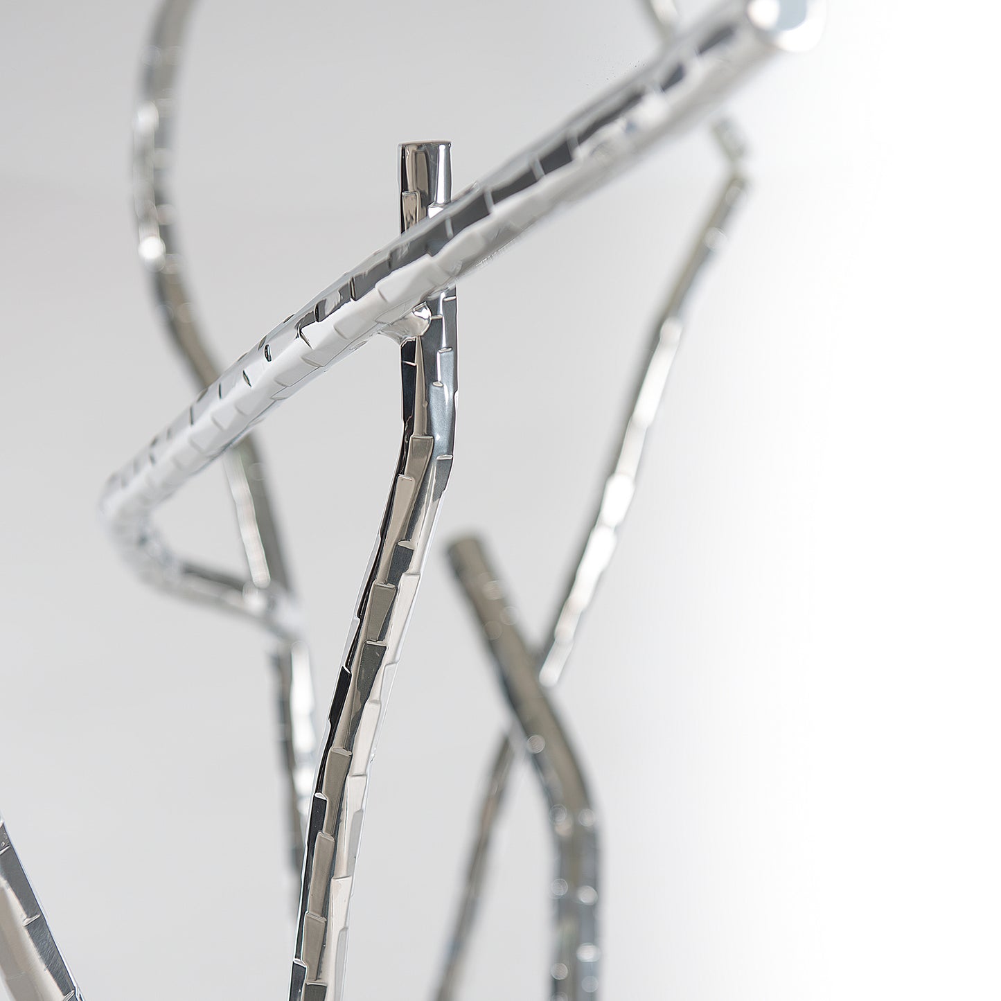 A close up image of a silver twig on a white background featuring the Hubbardton Forge Brindille Console Table.