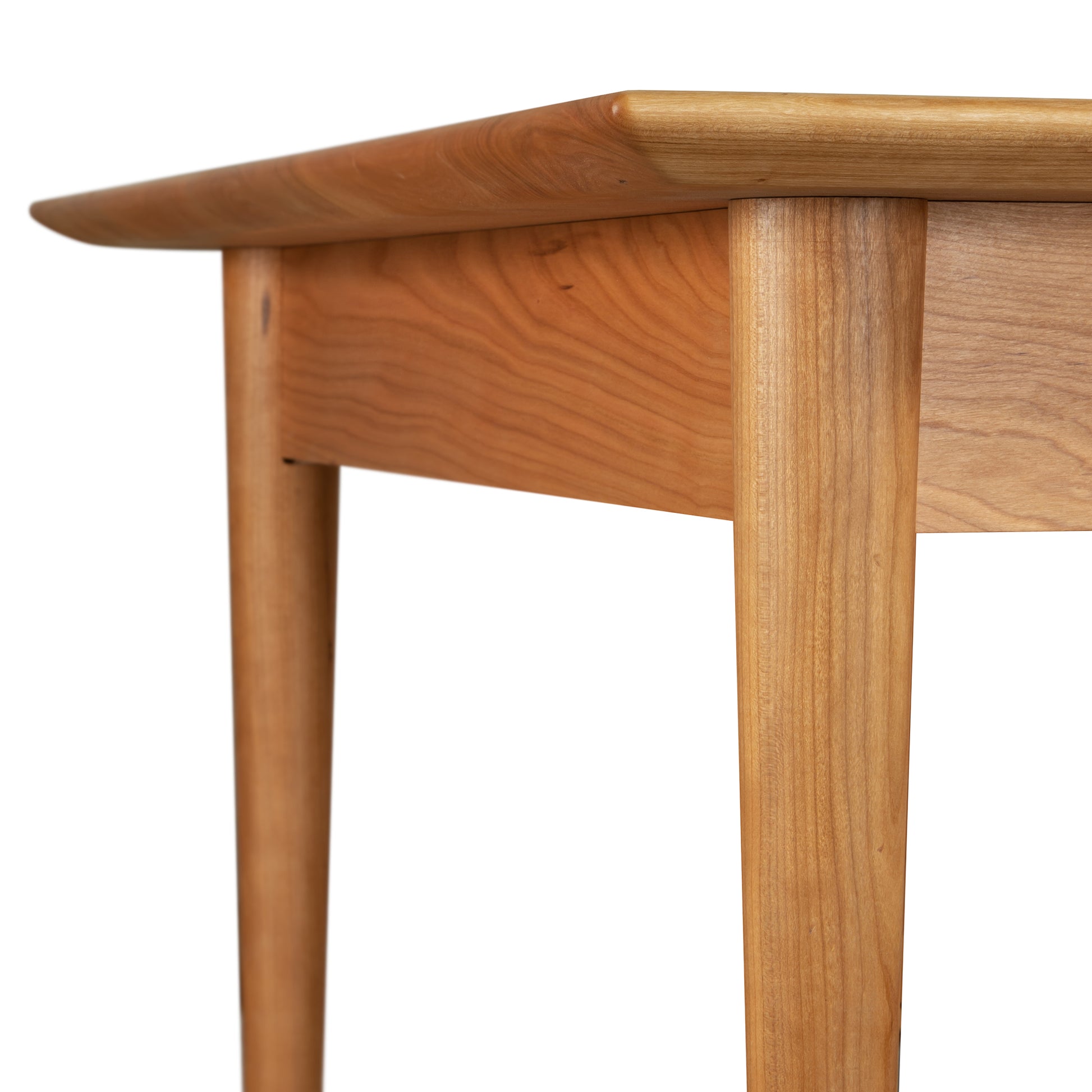 A close up of a Burke Modern Dining Table by Vermont Woods Studios, showcasing exquisite craftsmanship.