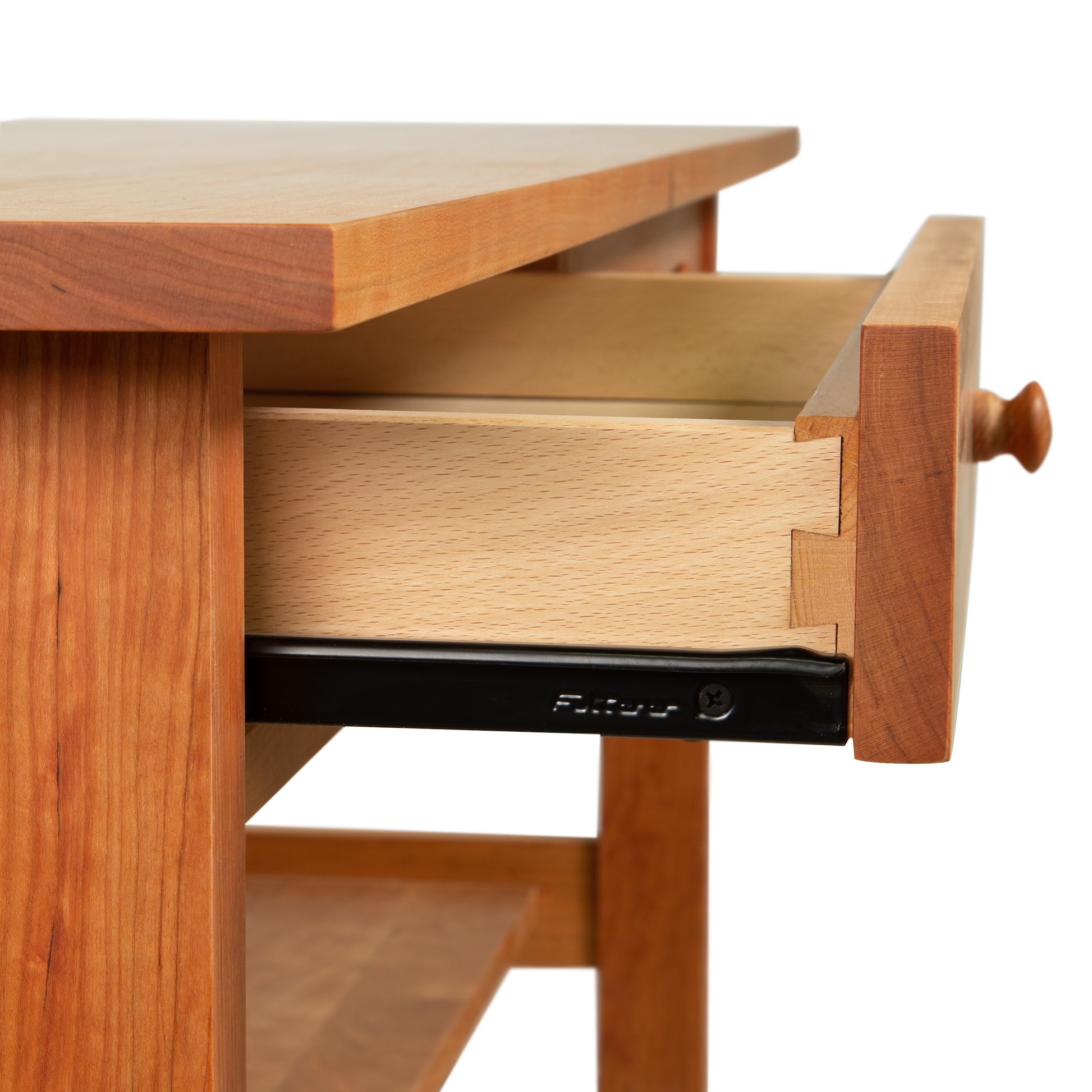 A Burlington Shaker 2-Drawer Coffee Table by Vermont Furniture Designs, with an open drawer, featuring dovetail joints and a metal slide mechanism.