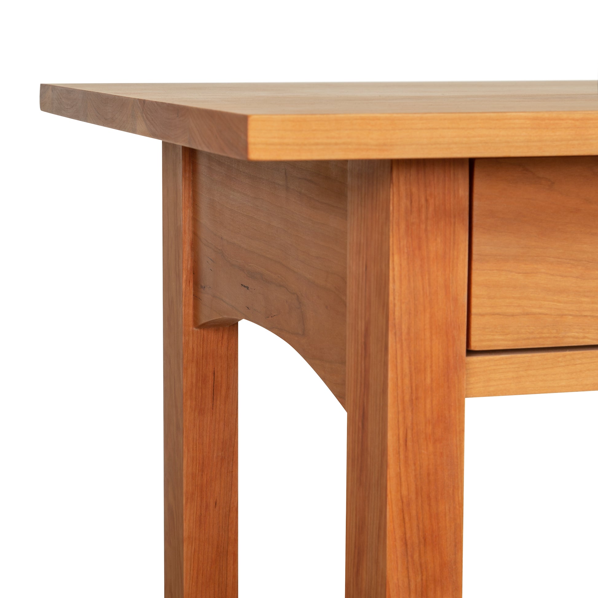 Corner of a Burlington Shaker 2-Drawer Coffee Table by Vermont Furniture Designs, showcasing its design and wood grain against a white background.