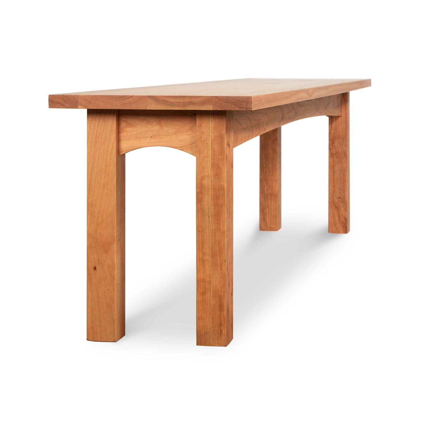 Burlington Shaker Bench by Vermont Furniture Designs with a flat wooden seat, robust legs, and arched support, shown against a plain background.