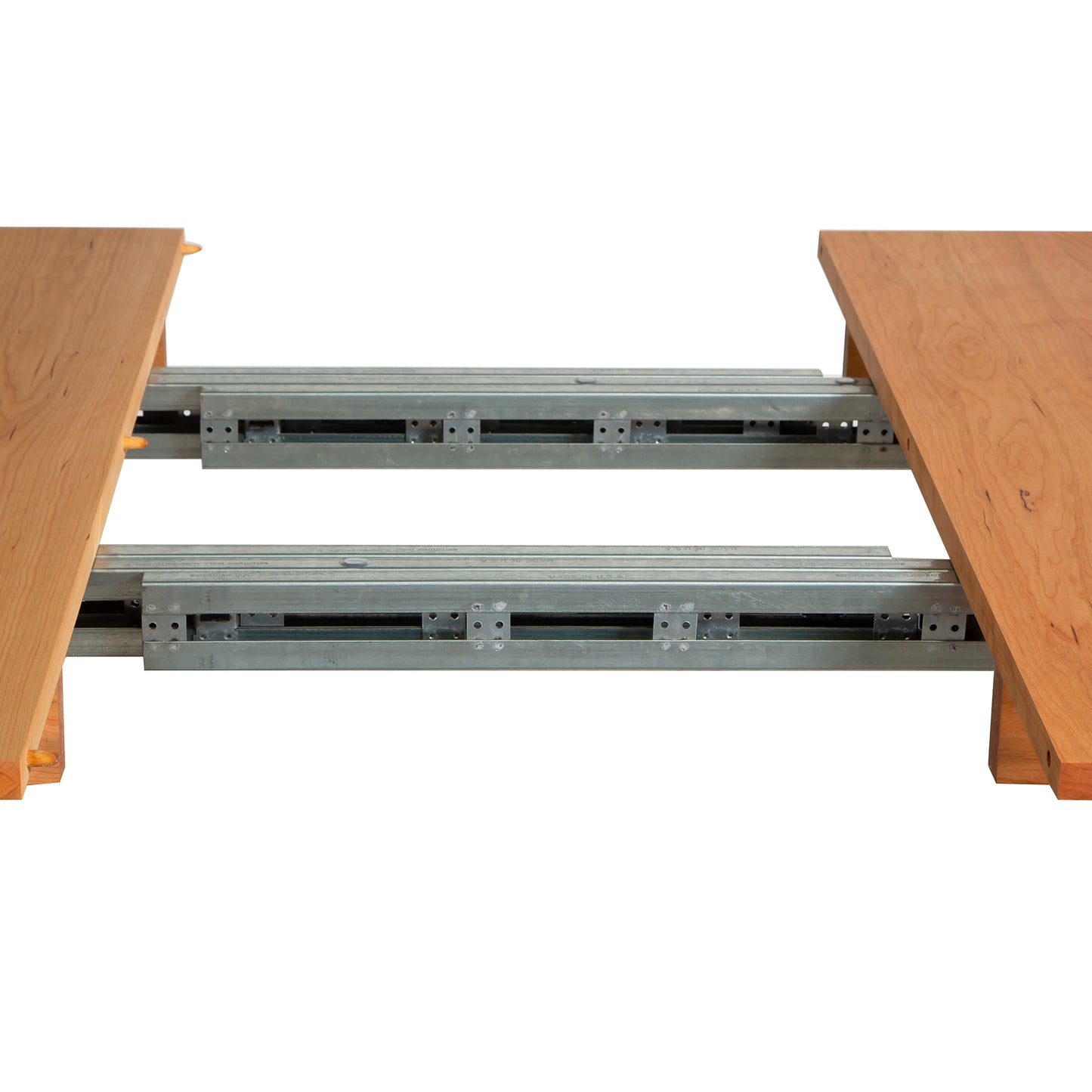 A Burlington Shaker Extension Dining Table - Floor Model by Vermont Furniture Designs is partially open, revealing the metal sliding mechanism beneath the tabletop. The environment is a plain white backdrop, emphasizing the structure of the table.
