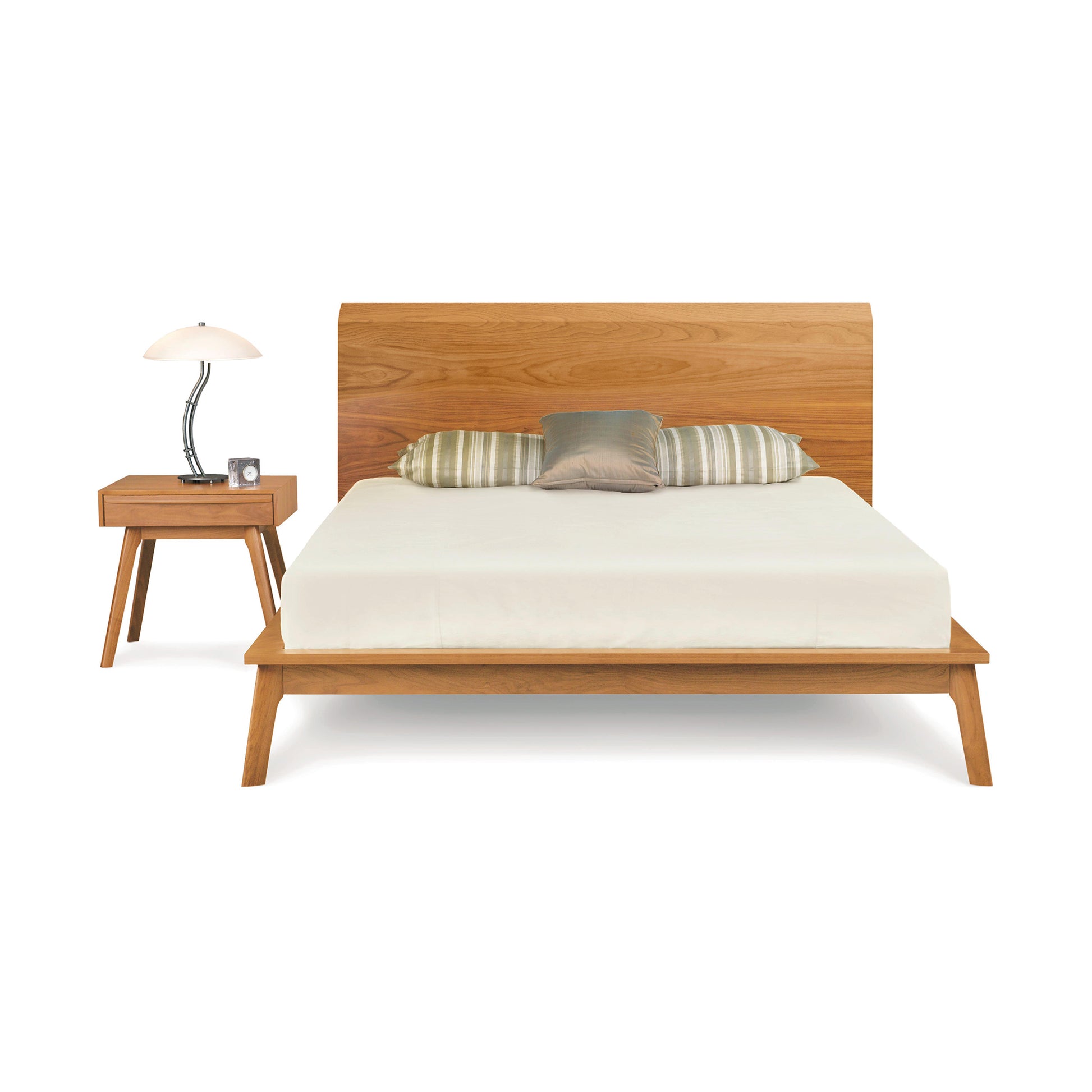 Catalina Platform Bed by Copeland Furniture showcasing a striking mid-century wooden frame, complemented by elegant striped pillows and an accompanying matching nightstand.