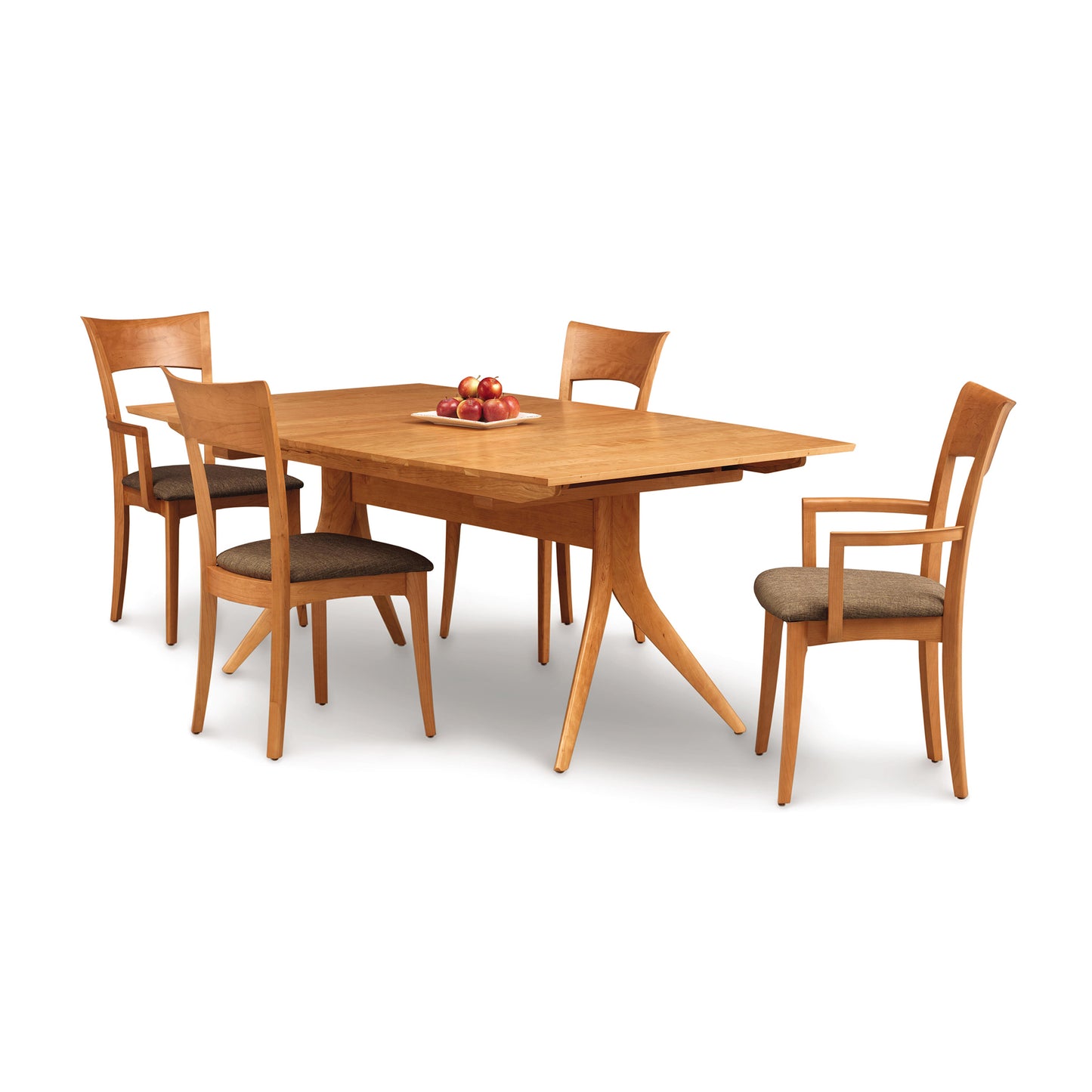 A solid American hardwood Catalina Trestle Extension Table with four matching chairs on a white background, with a small bowl of apples at the center of the table. (Brand: Copeland Furniture)