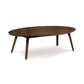 A Catalina Oval Coffee Table - Priority Ship, crafted from sustainable harvested hardwoods and manufactured by Copeland Furniture, featuring mid-century American styling with wooden legs.