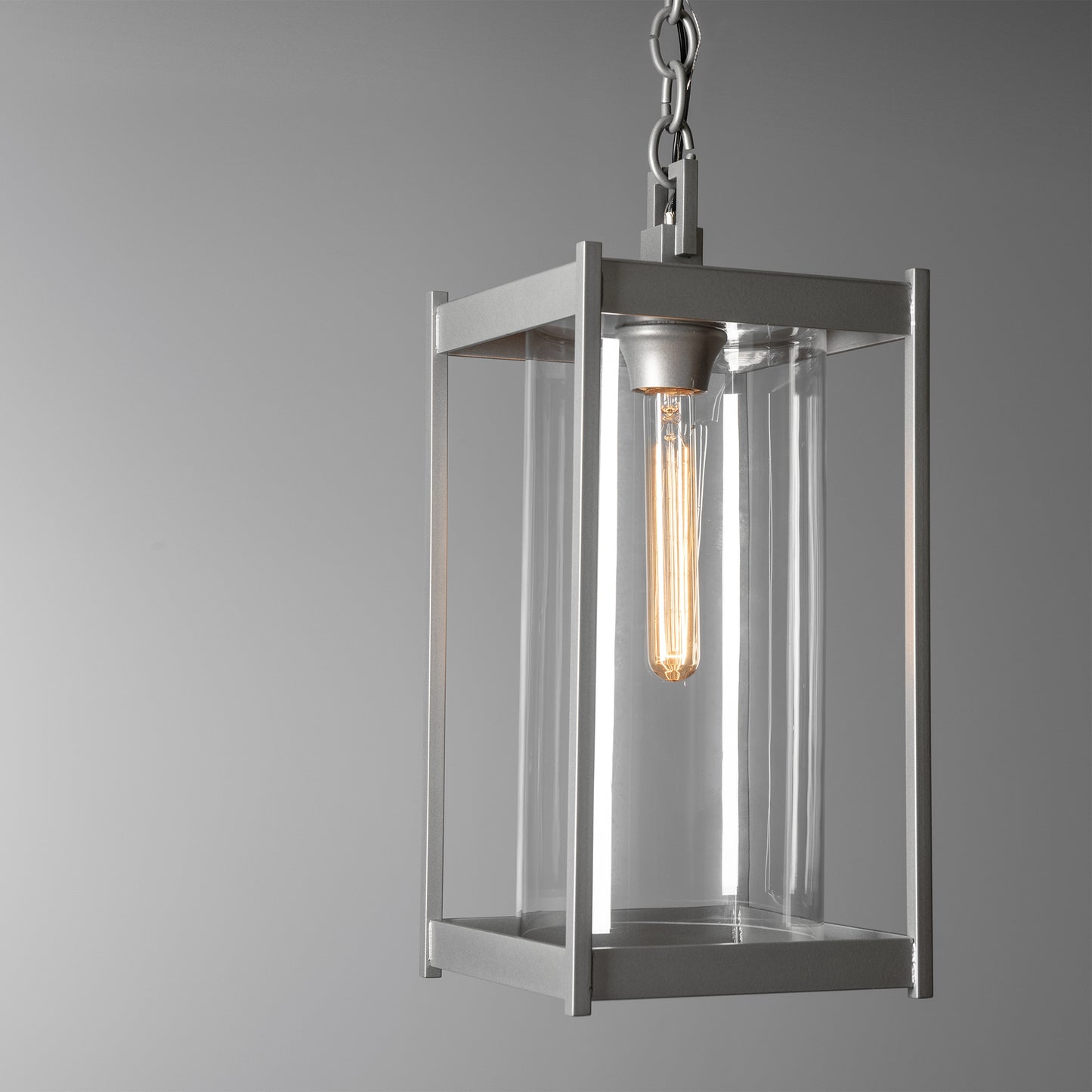 Cela Large Outdoor Lantern by Hubbardton Forge with clear glass panels, steel frame, and exposed bulb design hanging from a sturdy chain.