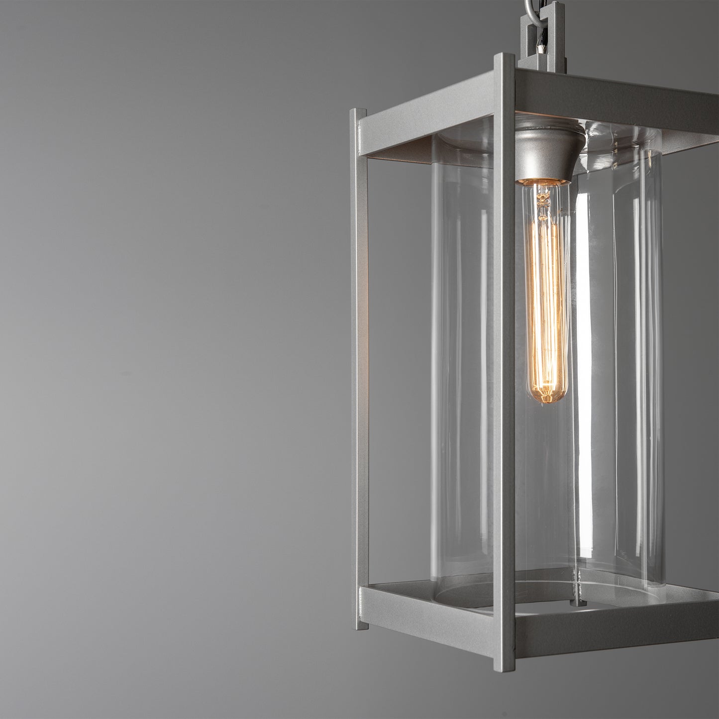 Cela Large Outdoor Lantern by Hubbardton Forge with clear glass body and glowing bulb, showcasing modern craftsmanship and elegant outdoor design.