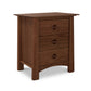 A Cherry Moon 3-Drawer Nightstand, featuring rounded edges and standing on four sturdy legs, representative of Maple Corner Woodworks craftsmanship, isolated on a white background.