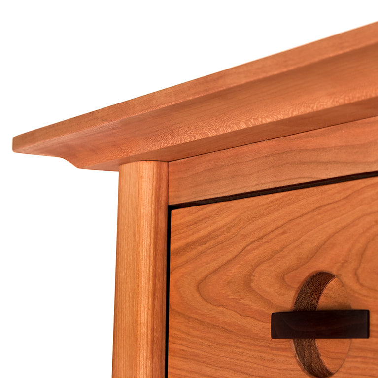 Close-up of Cherry Moon 5-Drawer Chest by Maple Corner Woodworks, showcasing smooth cherry wood and dark circular drawer handle.