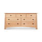 A Cherry Moon 7-Drawer dresser from Maple Corner Woodworks, featuring a light natural wood finish and round pull handles, isolated on a white background.