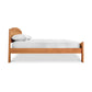 A Cherry Moon Bed from Maple Corner Woodworks with a white mattress and pillow, isolated on a white background.