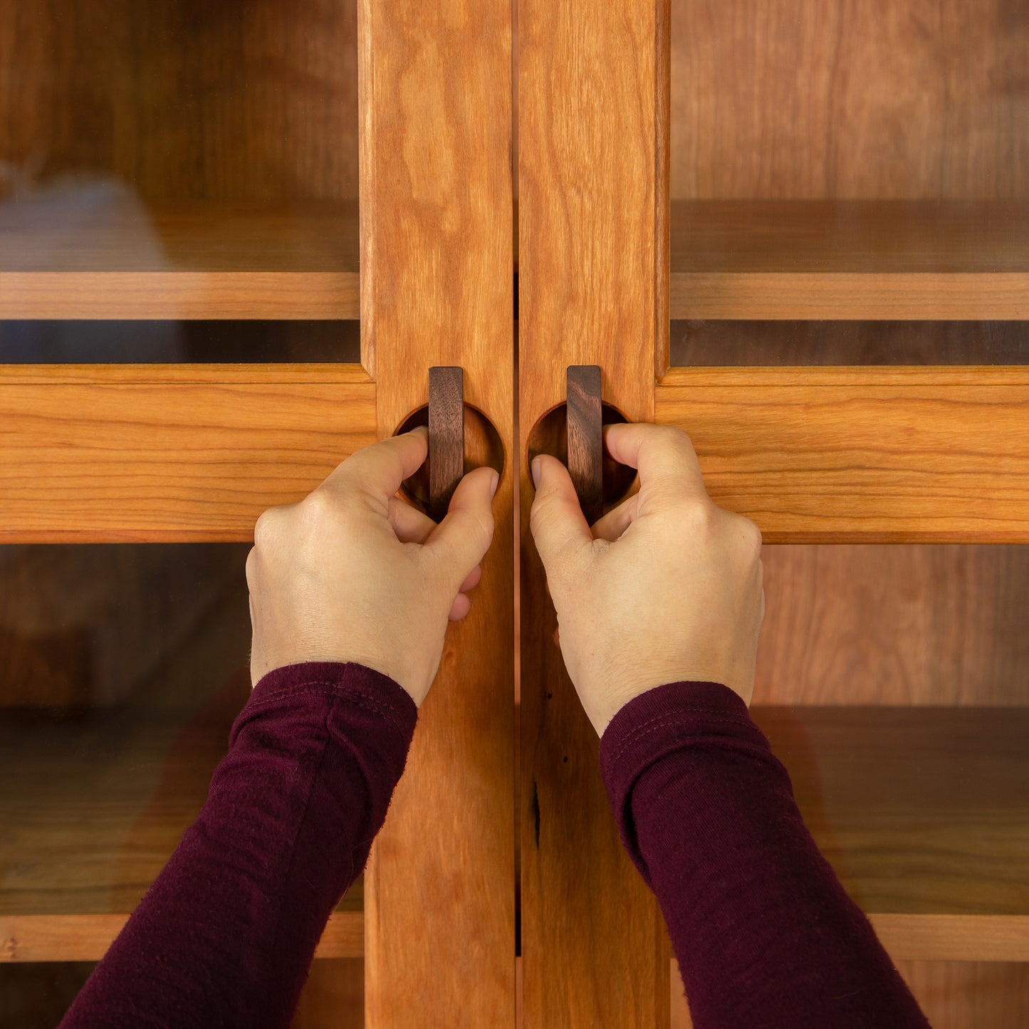 Cherry Moon Bookcase with Glass Doors by Maple Corner Woodworks, crafted from sustainable hardwood, shown being opened to display its quality details.