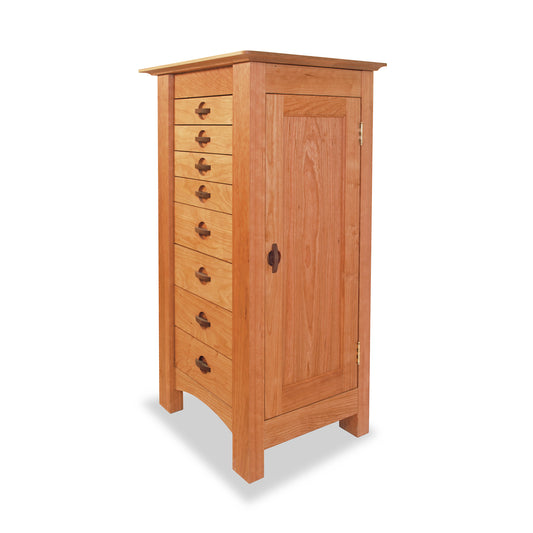A Maple Corner Woodworks Cherry Moon Jewelry Cabinet with multiple drawers on one side and a single door on the other, isolated on a white background.